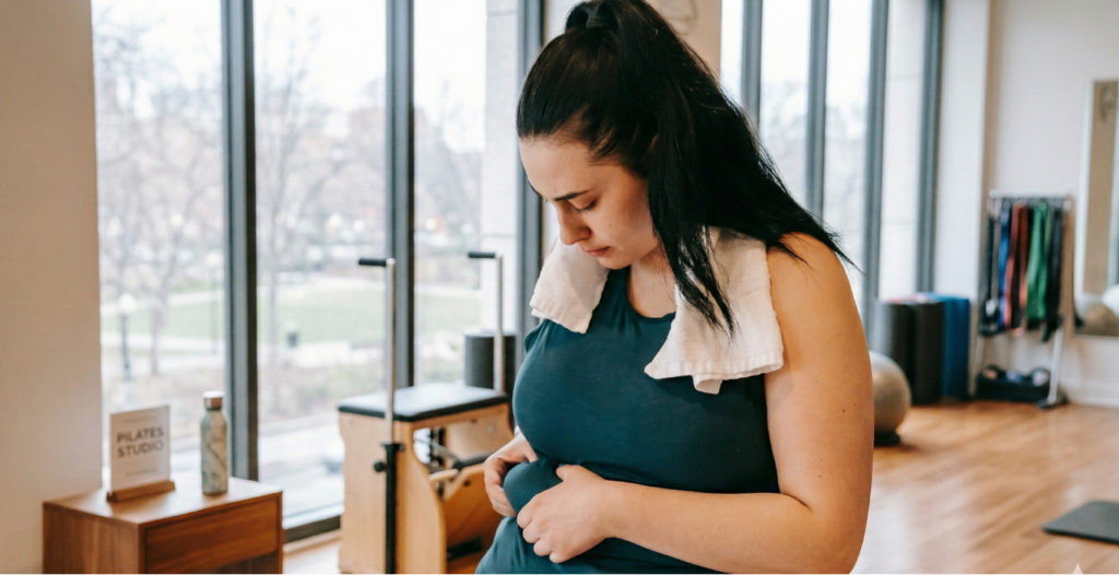 Femme en tenue de sport observant son ventre avec une sensation de fatigue et de stagnation, illustrant une résistance à l’insuline